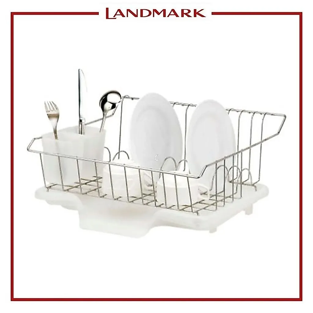 Masflex chrome wire countertop dish drainer on a white plastic drain tray with cutlery cup, holding plates and cups, angled view