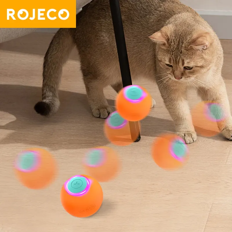 ROJECO orange self-rolling LED cat ball moving across a wood floor while a cat watches