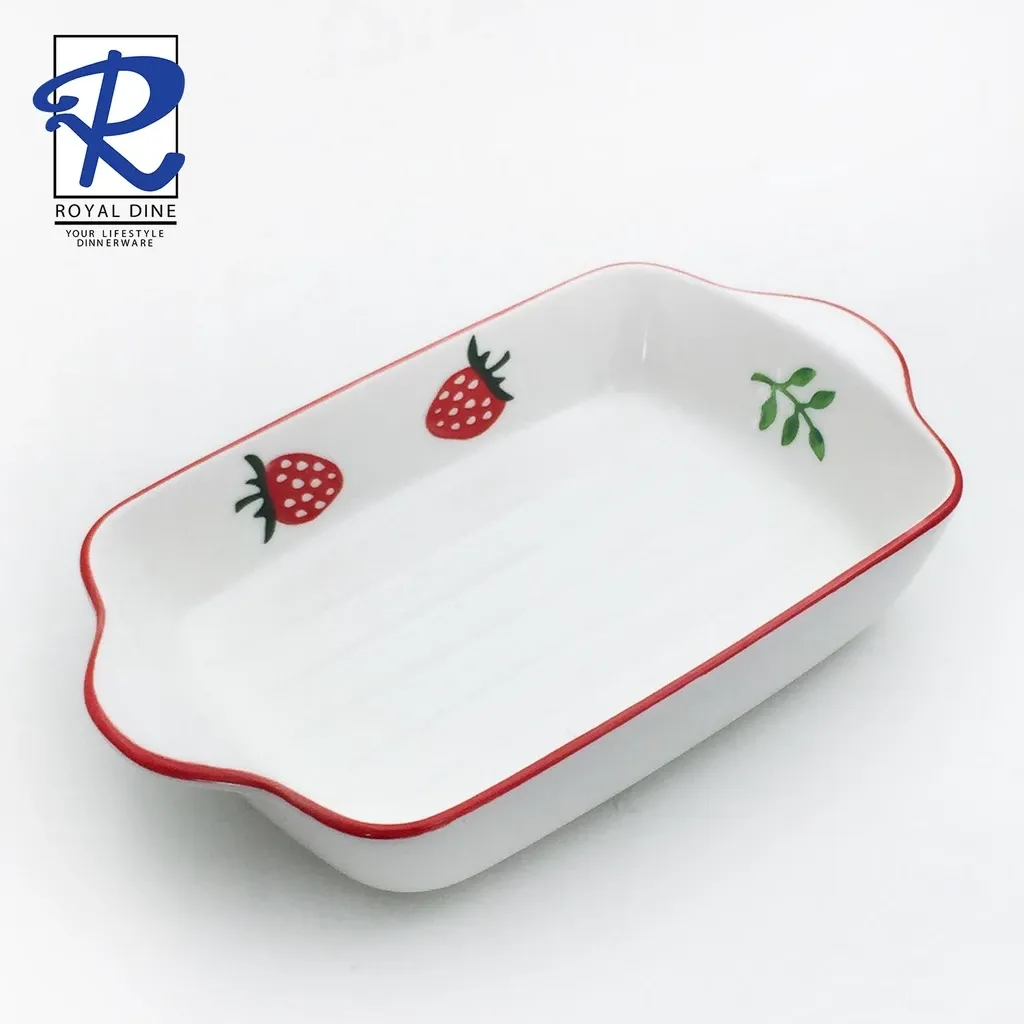 White ceramic baking dish with a red strawberry print pattern, 9 inch, angled view